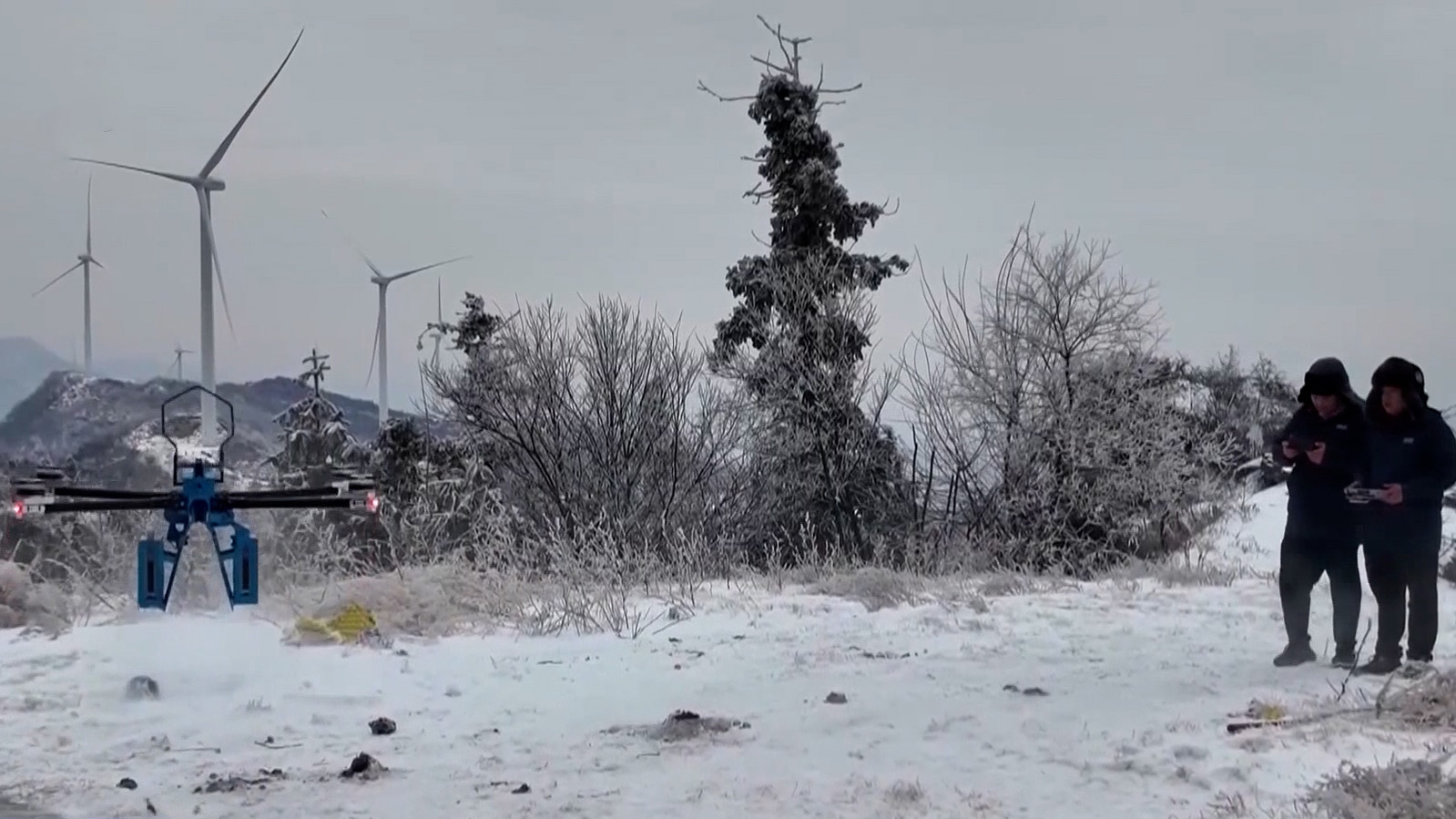 Two maintenance specialists control a four-rotor de-icing robot, January 20, 2026. /CMG