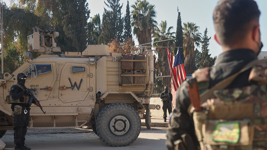 Fighters with the Syrian Democratic Forces (SDF) stand guard near a U.S. military vehicle from the U.S.-led coalition against the Islamic State group in Deir Hafer, Syria, on January 16, 2026. /VCG