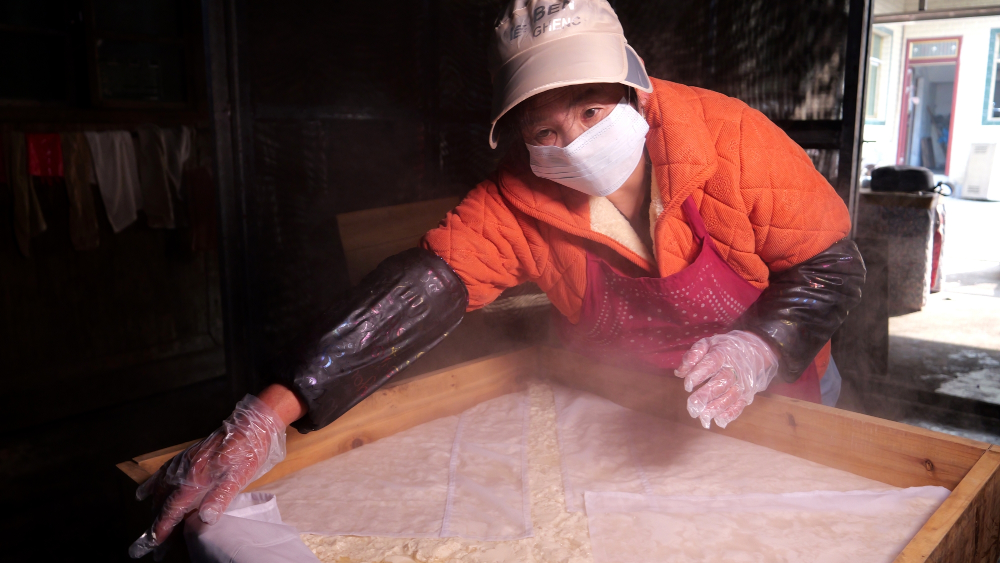 A woman makes traditional dried tofu in Shuichong Village, Tongren City, southwest China's Guizhou Province on January 14, 2026. /Tongren Media Convergence Center