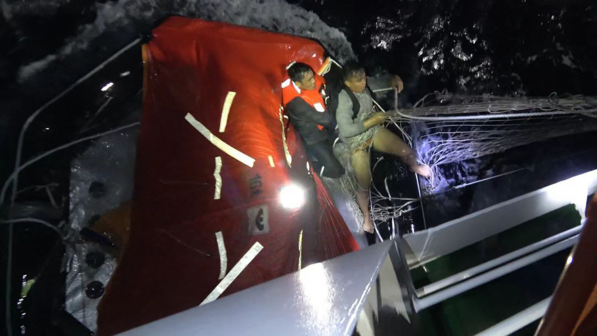 A China Coast Guard personnel rescues a Filipino crew member of a capsized cargo ship near China's Huangyan Dao in the South China Sea, January 23, 2026. /VCG