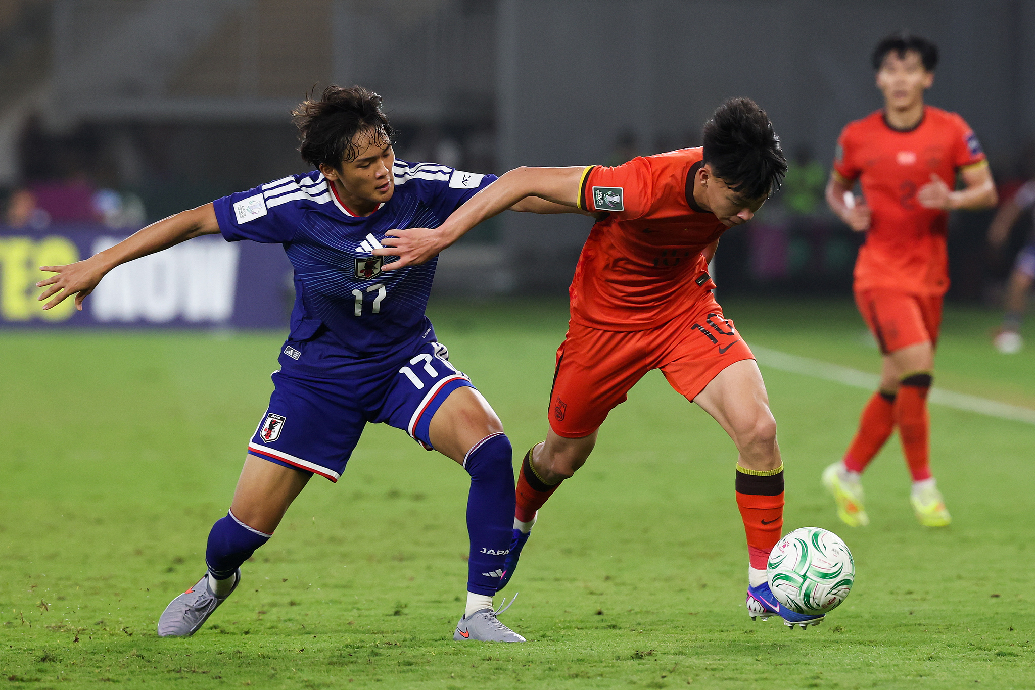China's Wang Yudong (C) battles for the ball against Japan's Yudai Shimamoto in the AFC Under-23 Asian Cup final in Jeddah, Saudi Arabia, January 24, 2026. /VCG