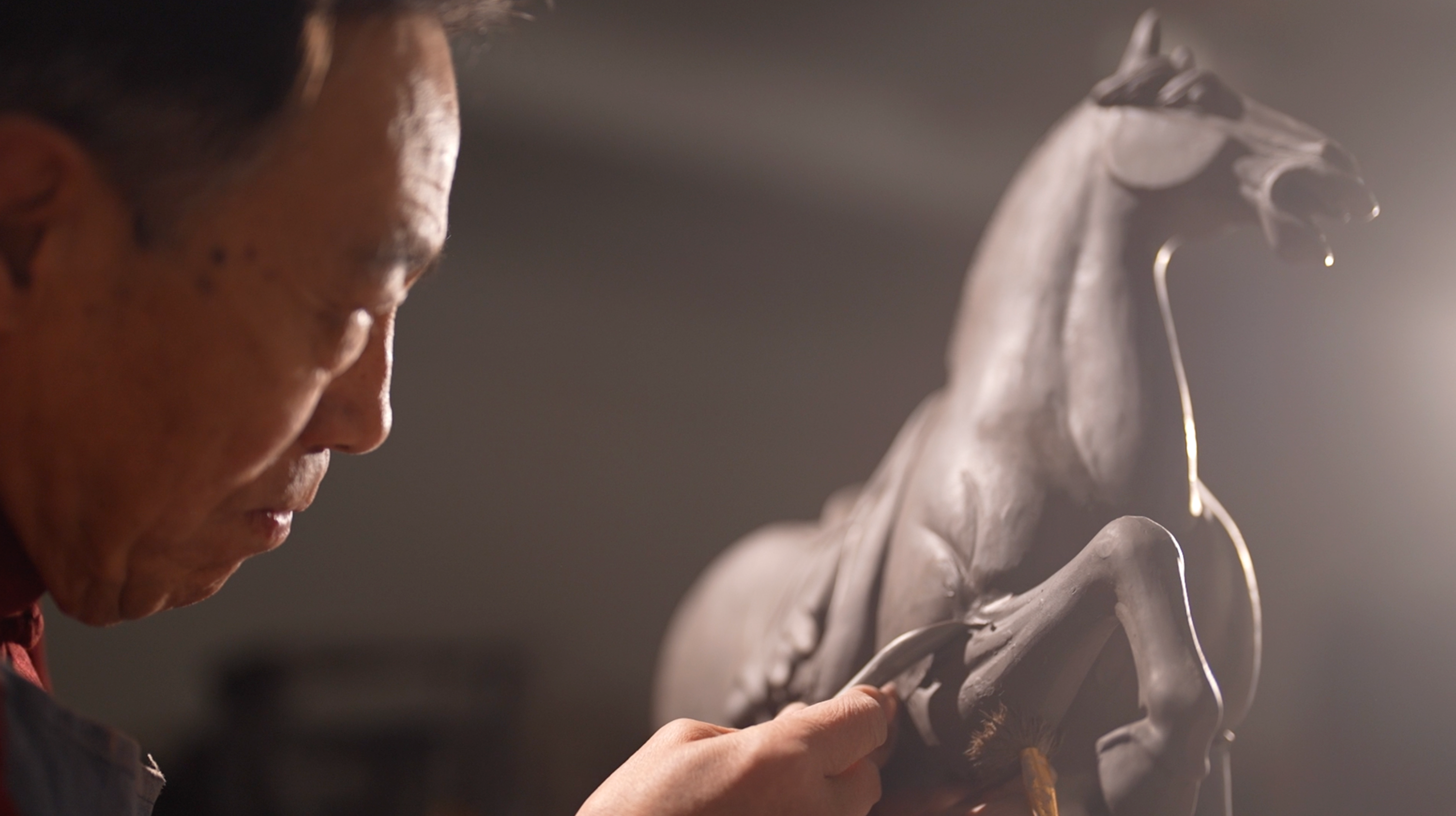 Gao Shuiwang carving the mold for a horse pottery. /CGTN