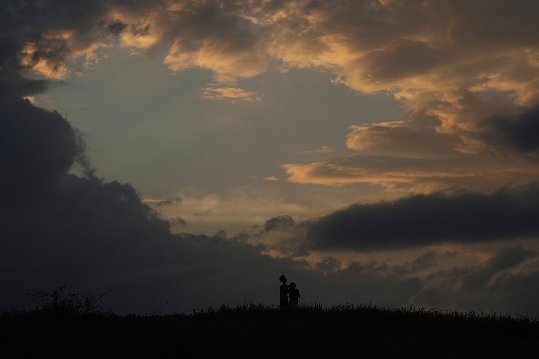 A couple watches as a storm passes in San Antonio, the U.S., July 15, 2025. /VCG