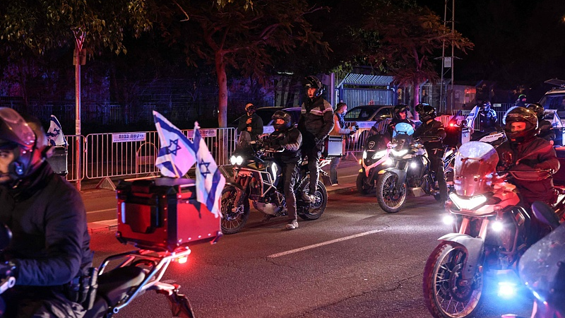 Israeli police officers and others ride their motorbikes towards the Abu Kabir Forensic Institute, as the body of the last Israeli hostage arrives by ambulance in Tel Aviv, January 26, 2026. /VCG