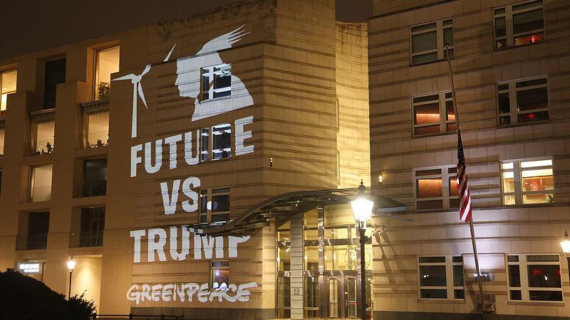 Greenpeace activists project an illumination showing a wind turbine and that reads: 
