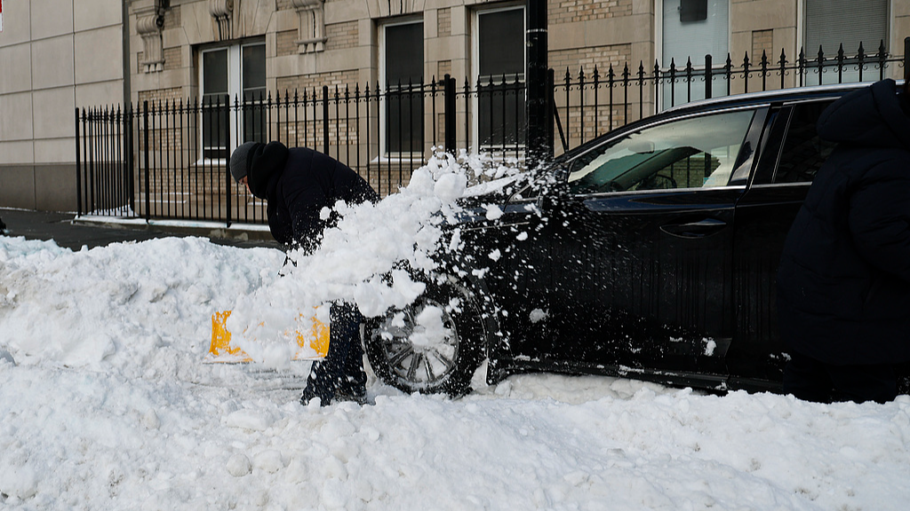 A man digs out his car from a snowbank in New York City, U.S., January 26, 2026. /VCG