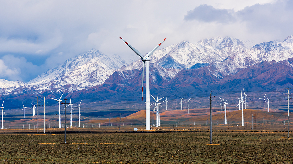 A wind farm stands at the foot of the Tianshan mountains in Xinjiang Uygur Autonomous Region, northwest China. / VCG