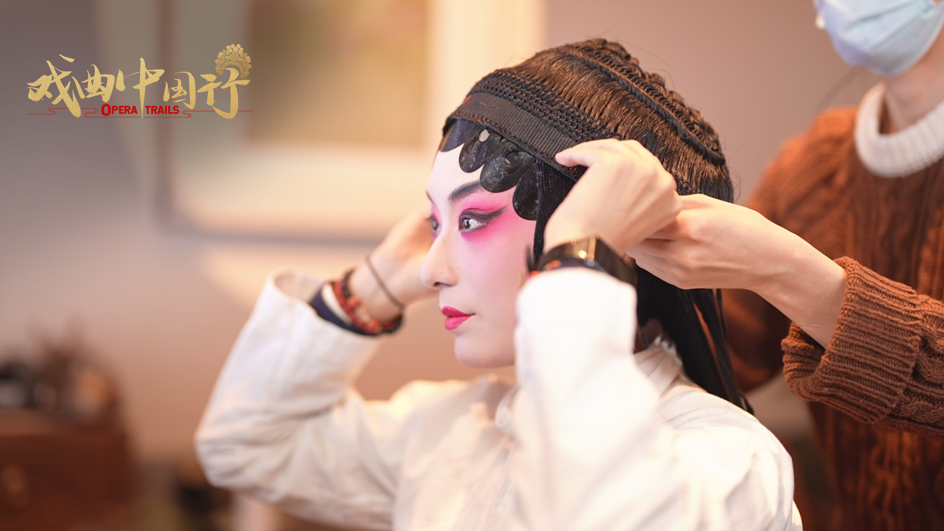 Hou Yu puts on her headdress before taking the stage at Yanliao Guild Hall, Dongcheng District, Beijing, China. /CGTN