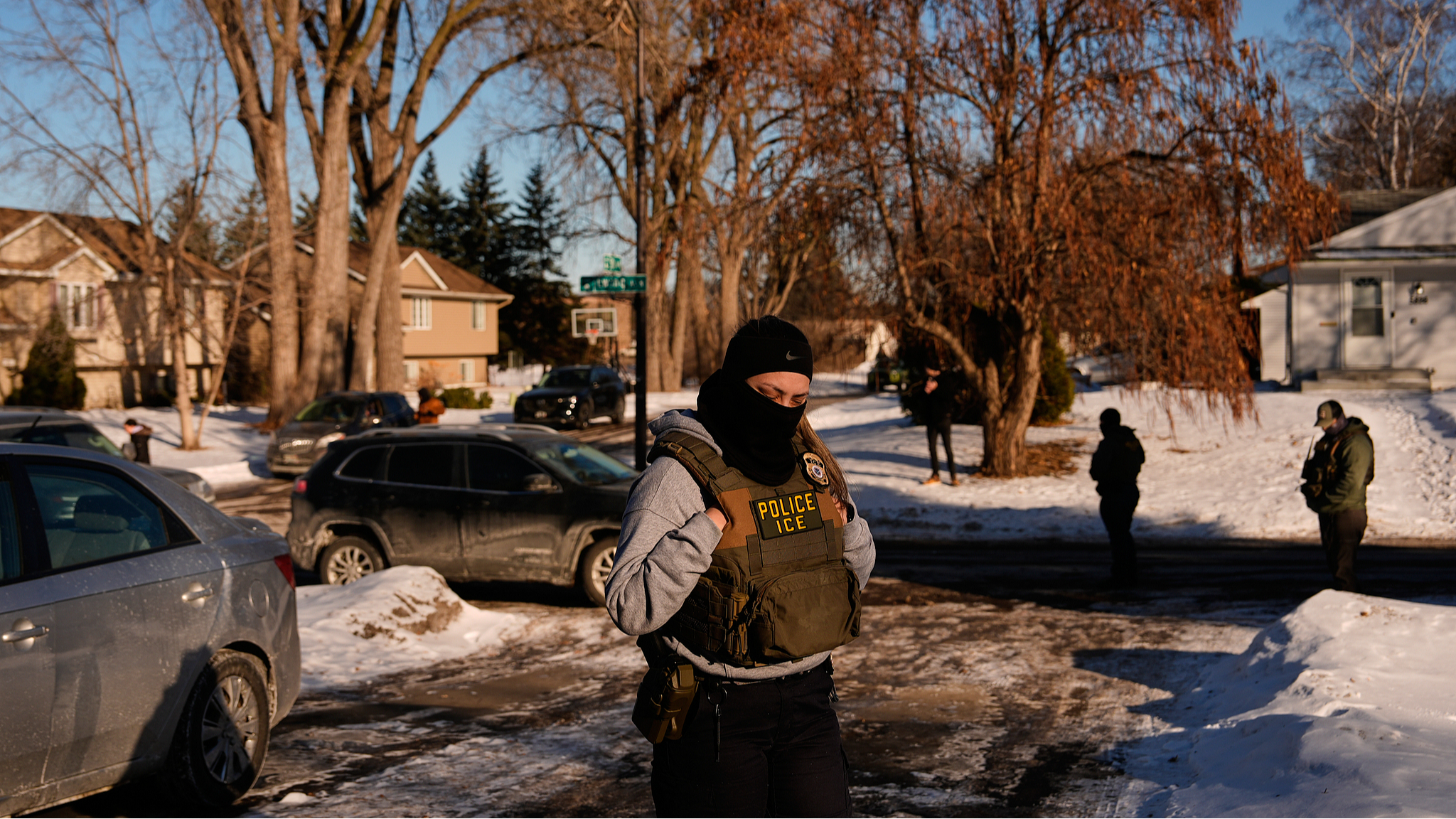 A federal immigration officer looks on as other officers knock on the door of a residence in Brooklyn Center, Minnesota, U.S., January 28, 2026. /VCG