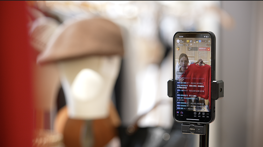 A phone shows a livestreamer selling clothes at E-Fashion Town in Hangzhou, Zhejiang Province, China. /CGTN