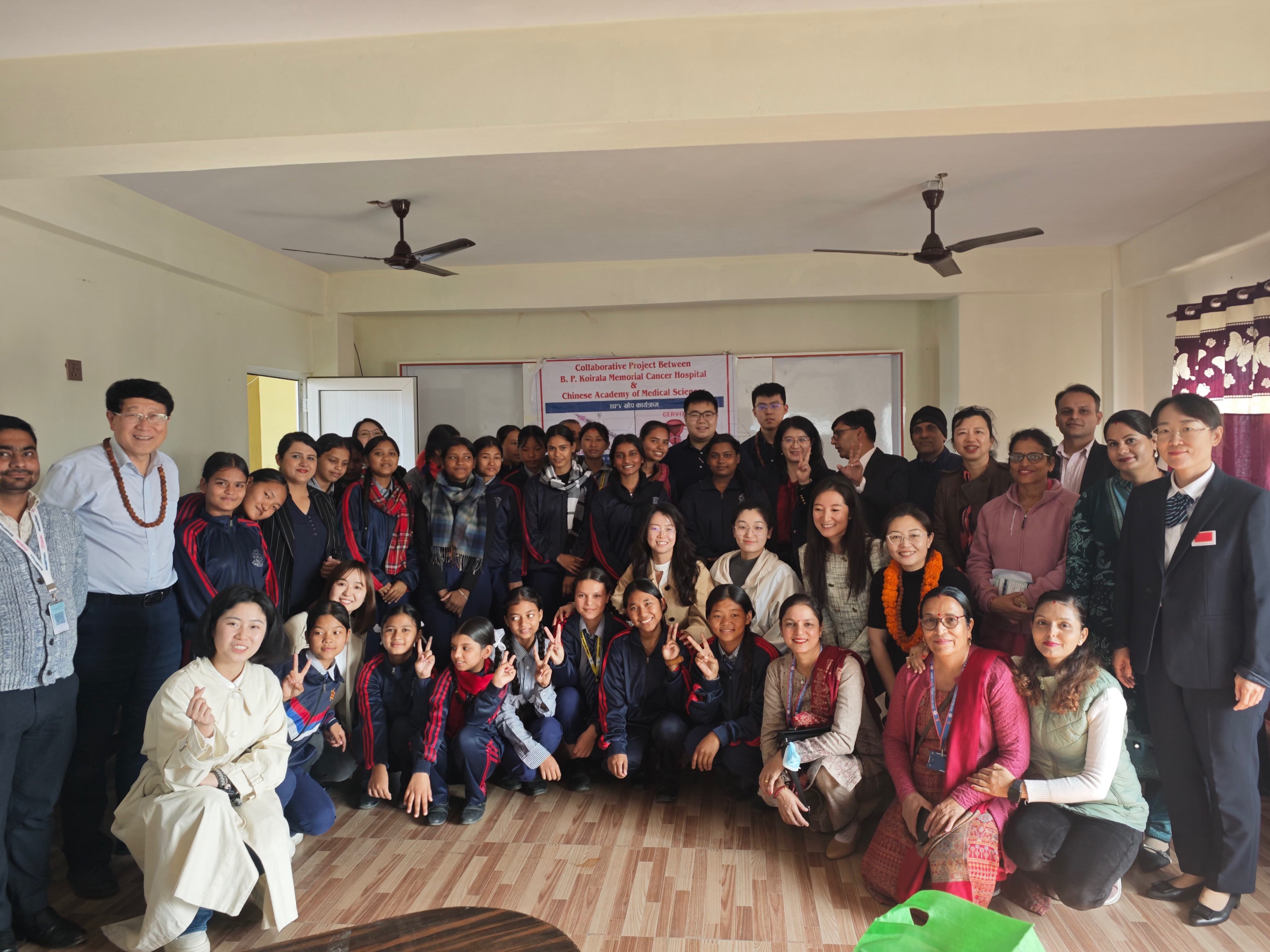 Zhao Fanghui (third row, eighth from right) and her team take a group photo with local staff and girls while providing HPV vaccination services in Nepal, 2024. /Courtesy of Zhao Fanghui