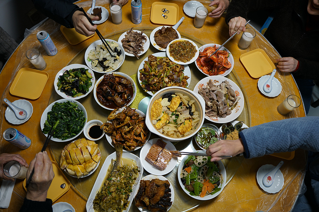 The reunion dinner is when family from near and far gather on New Year's Eve to eat, reaffirm family bonds and bid farewell to the previous year as they welcome the new. /VCG
