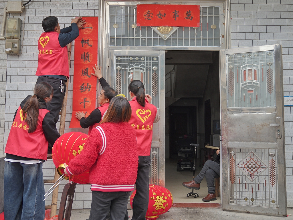 Red paper cuttings and couplets are pasted on walls and doorways in preparation for the Spring Festival. /VCG