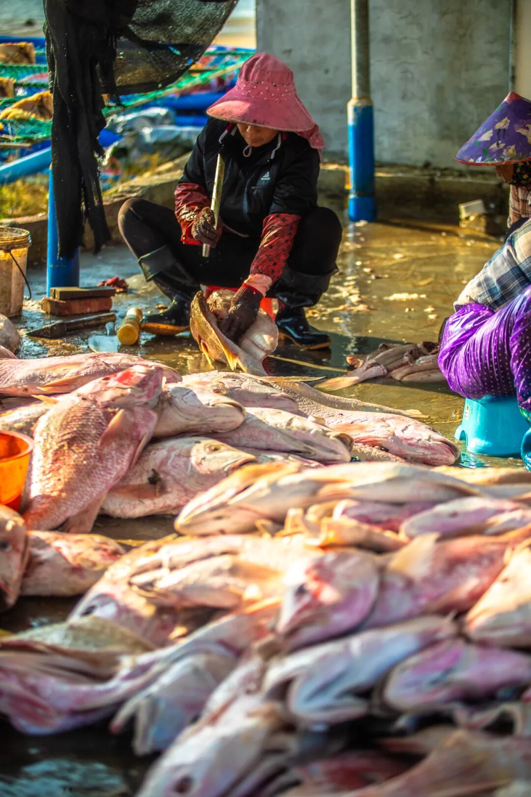 Fishermen are busy preparing auspicious dried red fish, a traditional Spring Festival specialty in Danzhou, Hainan. /Photo provided to CGTN