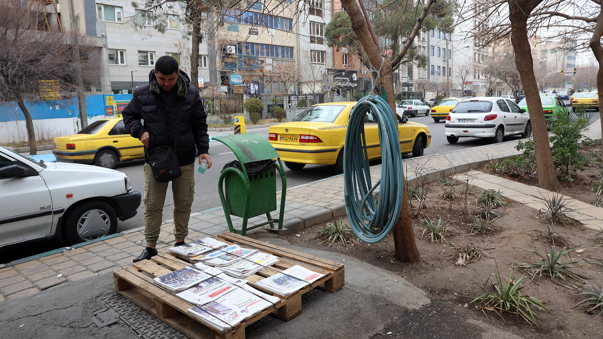 An Iranian man looks at the copies of Iranian daily newspapers reporting about first round of talks between Iran and the U.S., outside a kiosk in Tehran, Iran, February 7, 2026. /VCG