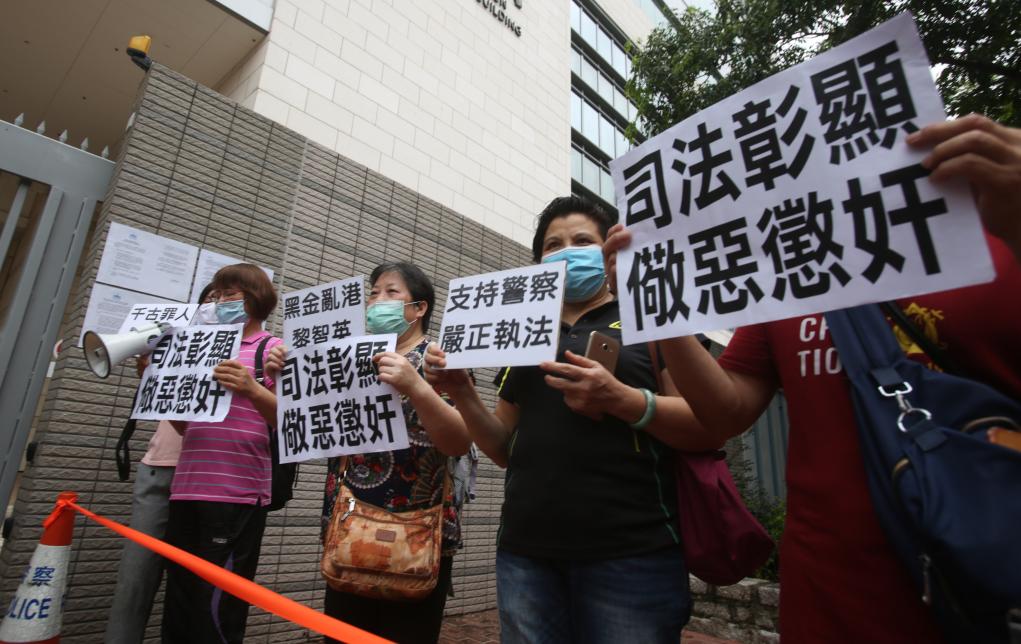 Demonstrators outside the West Kowloon Magistrates' Courts in Hong Kong, China, hold banners condemning Jimmy Lai and his accomplices for inciting riots and call for their severe punishment, May 18, 2020. /Xinhua