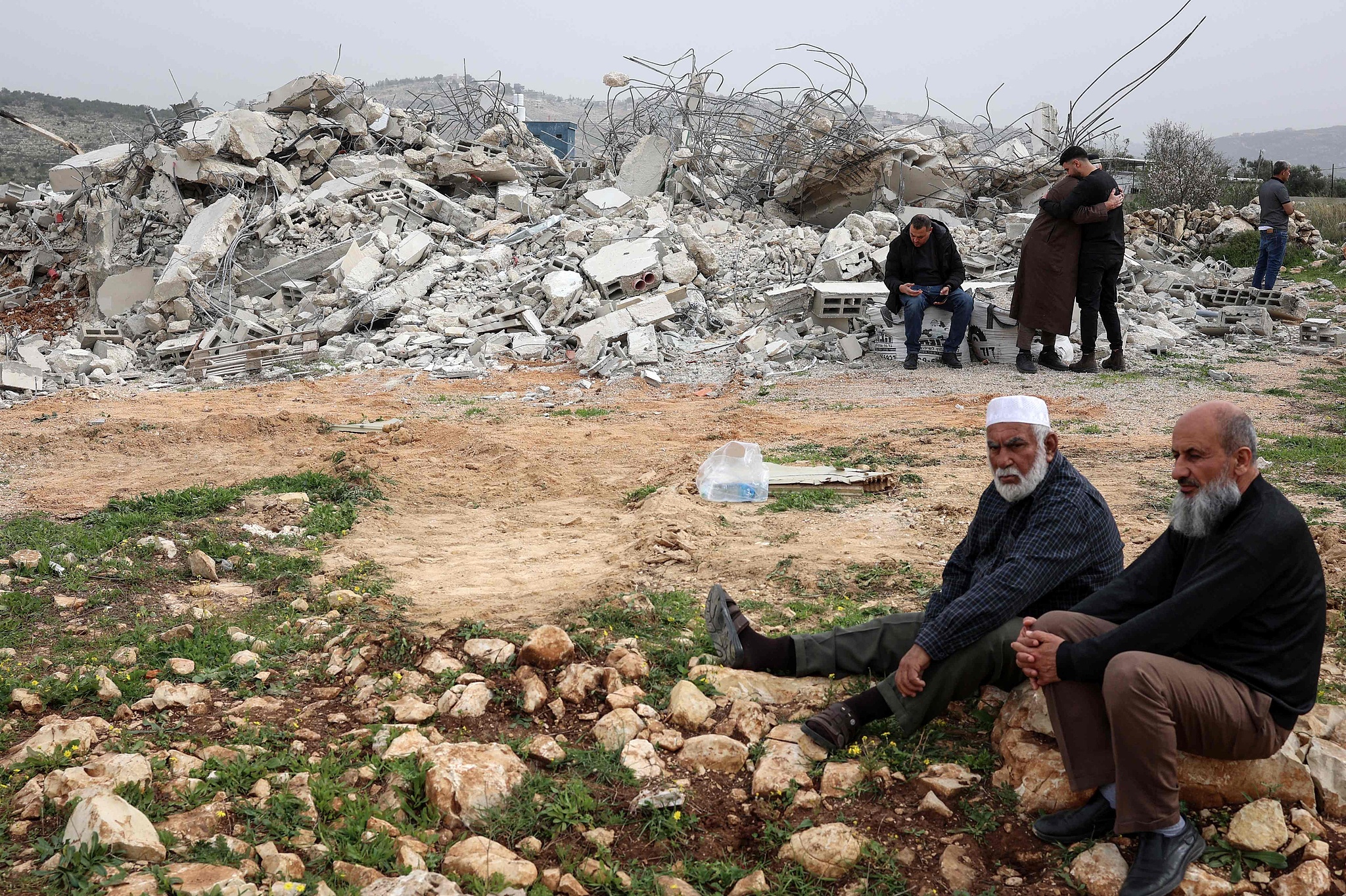Palestinian men sit on the rubble of a Palestinian home that was demolished by the Israeli army in the village of Shuqba, west of the city of Ramallah, in the Israeli-occupied West Bank, February 9, 2026. /VCG