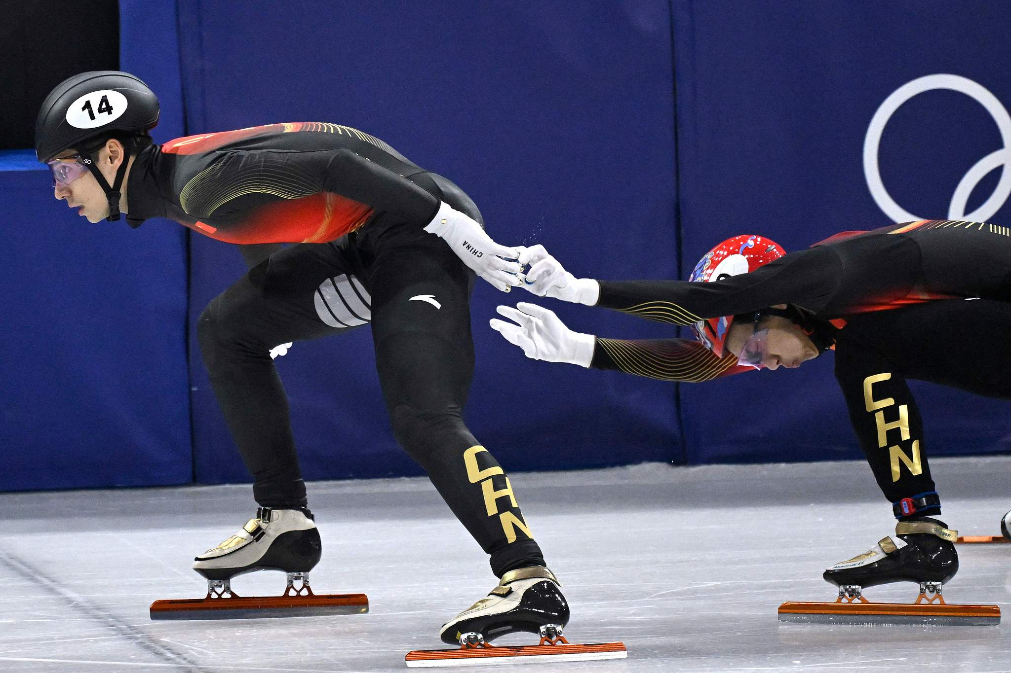 Liu Shaoang (L) and Sun Long of China compete in the short track speed skating mixed team relay event at the 2026 Milano Cortina Winter Olympics in Milan, Italy, February 10, 2026. /VCG