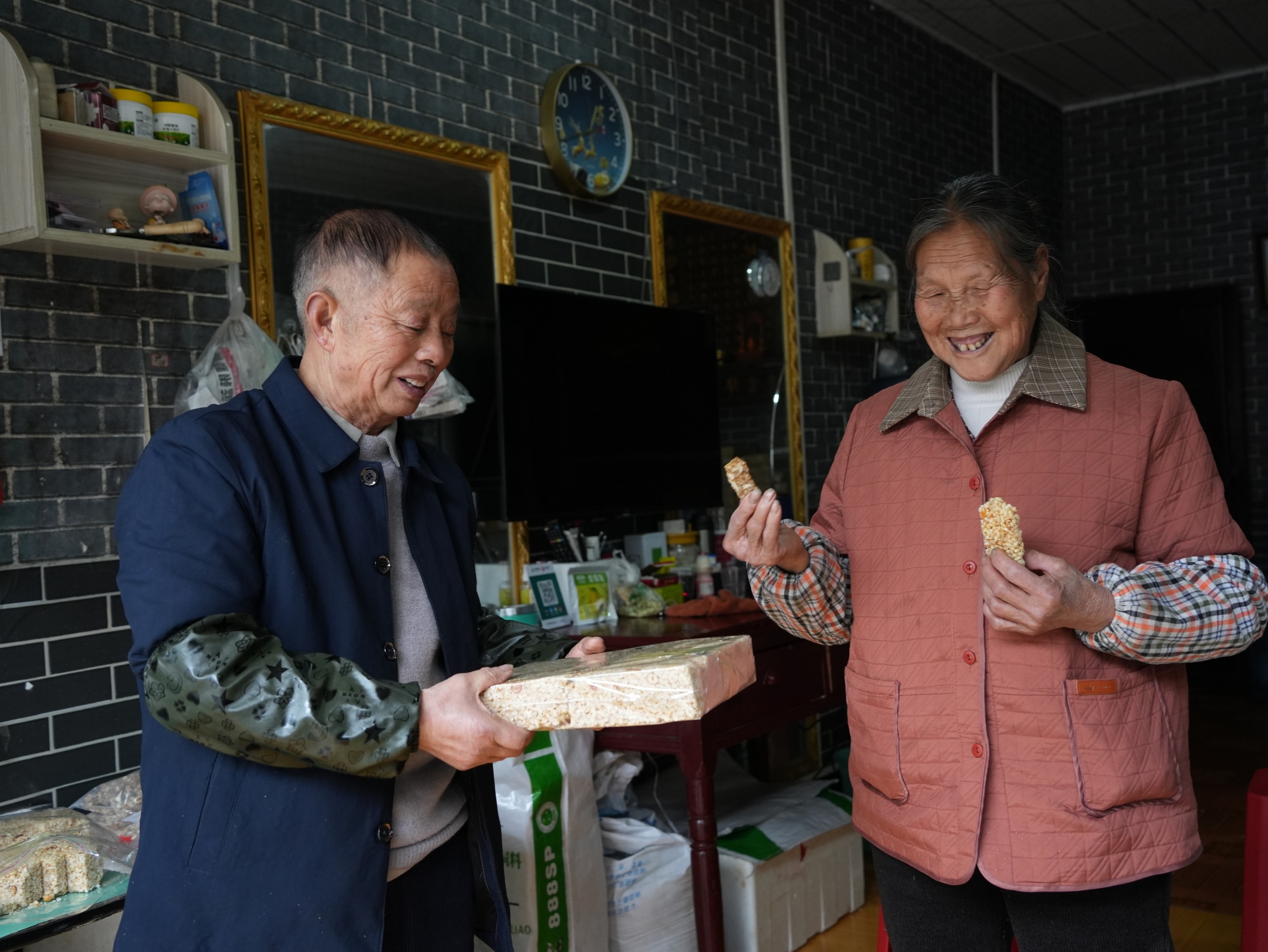 A woman (right) enjoys a sesame cake in Dejiang County, southwest China's Guizhou Province, on February 2. 2026. /Tongren Media Convergence Center