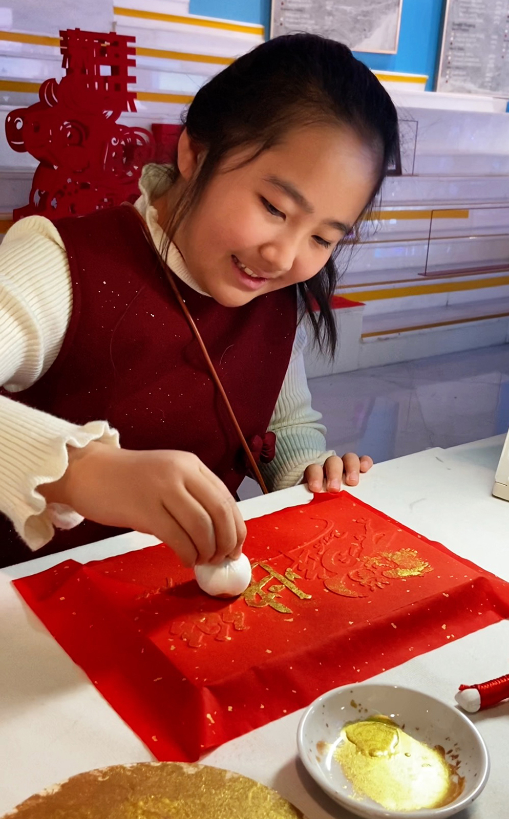 A girl participates in a traditional rubbing workshop at the Beijing Olympic Museum. /CGTN