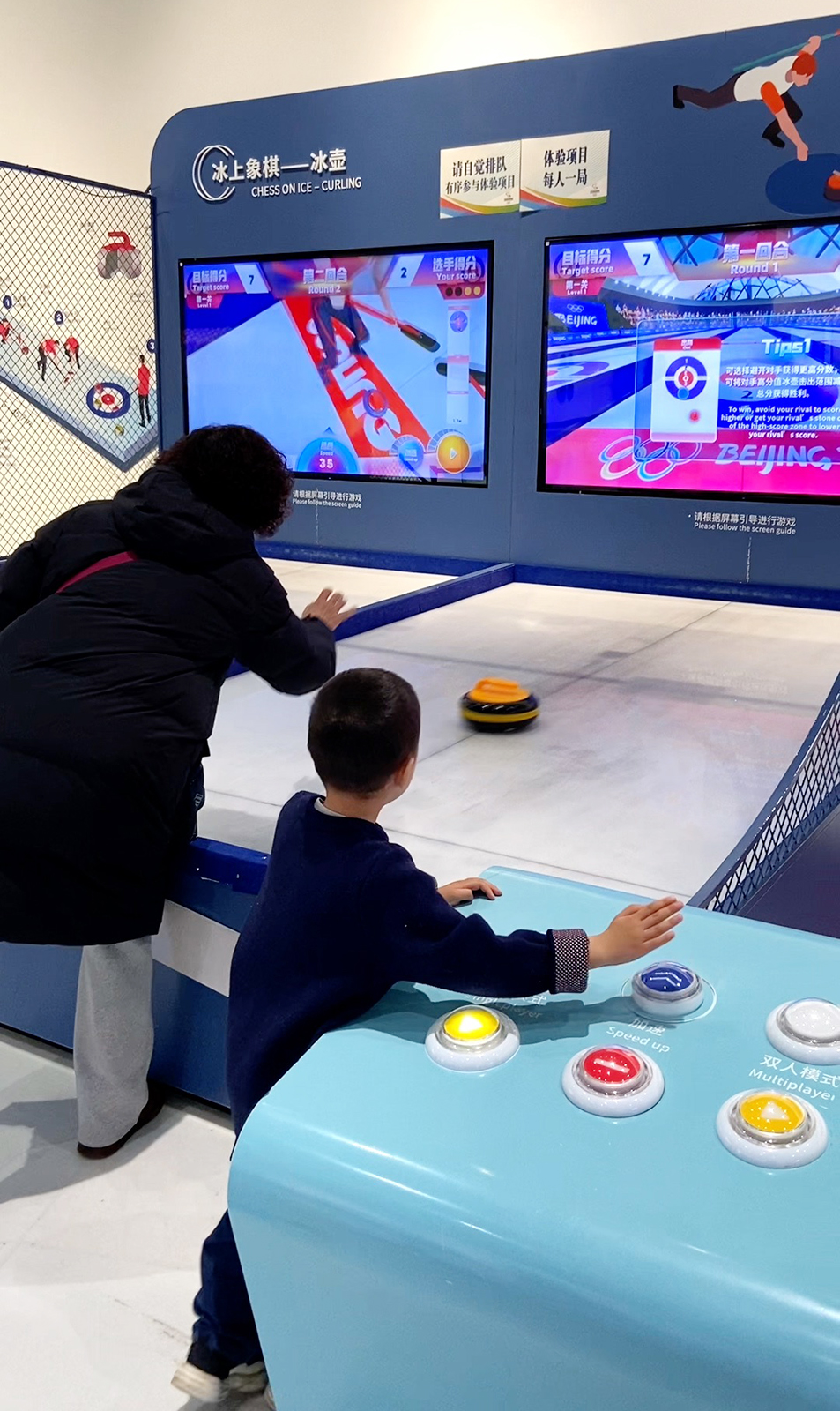 Visitors take part in a simulated curling experience at the Beijing Olympic Museum. /CGTN