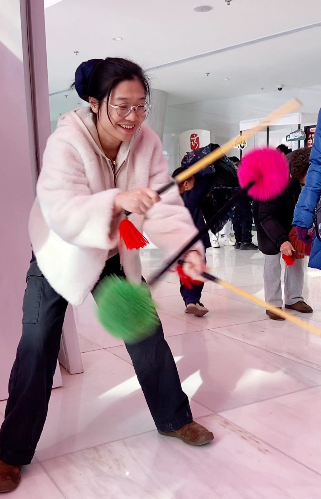 A visitor tries huagun, a traditional stick sport, at the Beijing Olympic Museum. /CGTN