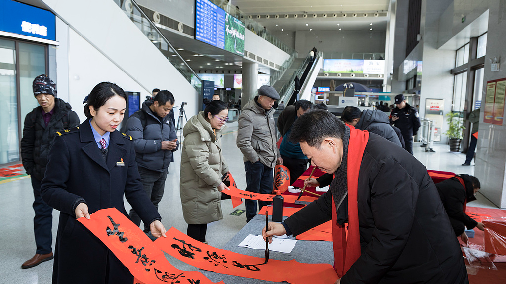 Calligraphers write Spring Festival couplets for travelers at a train station, Huaian City, east China's Jiangsu Province, February 1, 2026. /VCG