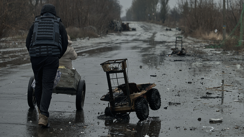 Volunteers transport an elderly woman in a wheelchair in the Donetsk region on February 13, 2026. /VCG