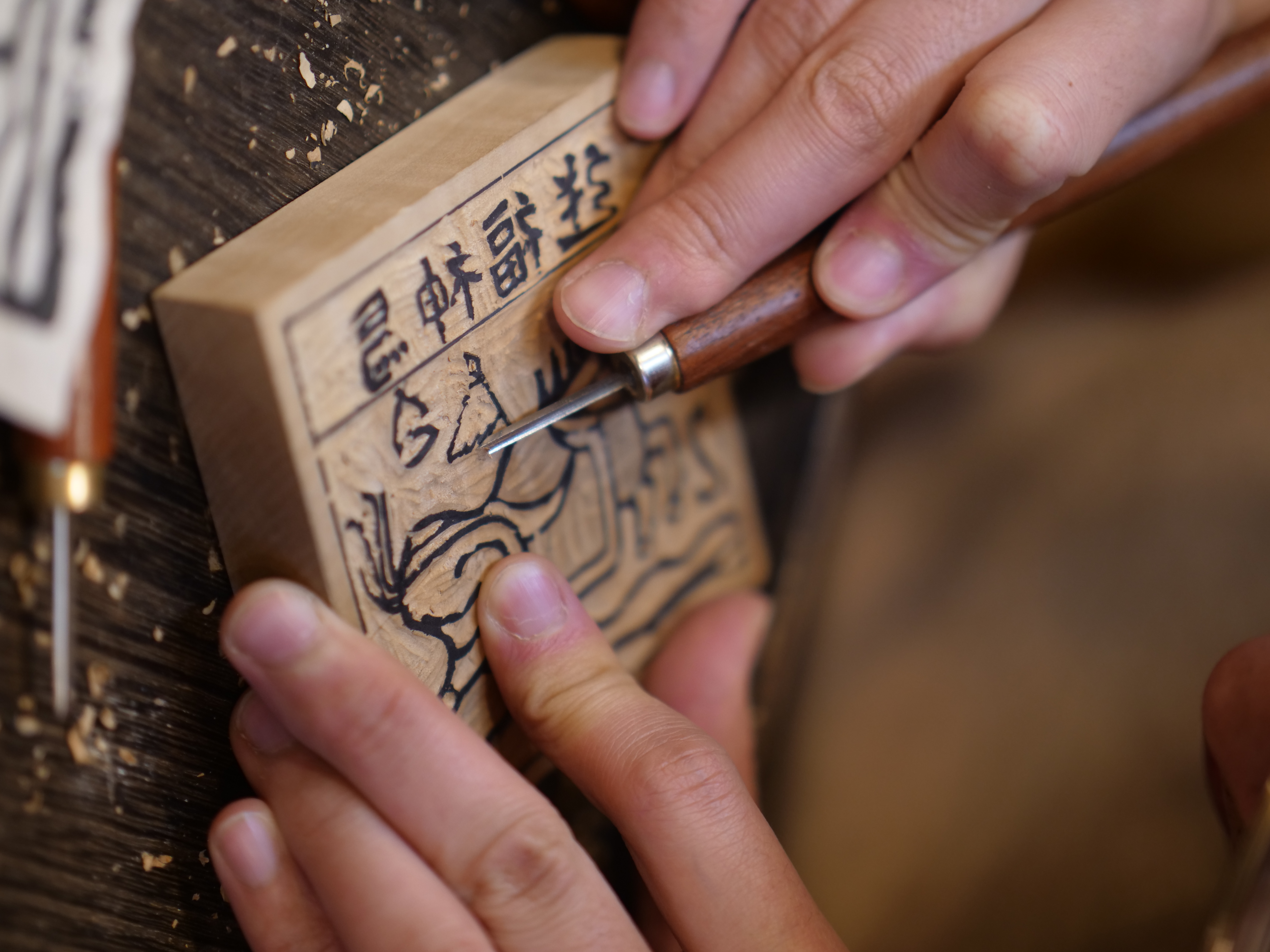 The second step is carving away the excess wood along the lines on the wooden block. /CGTN