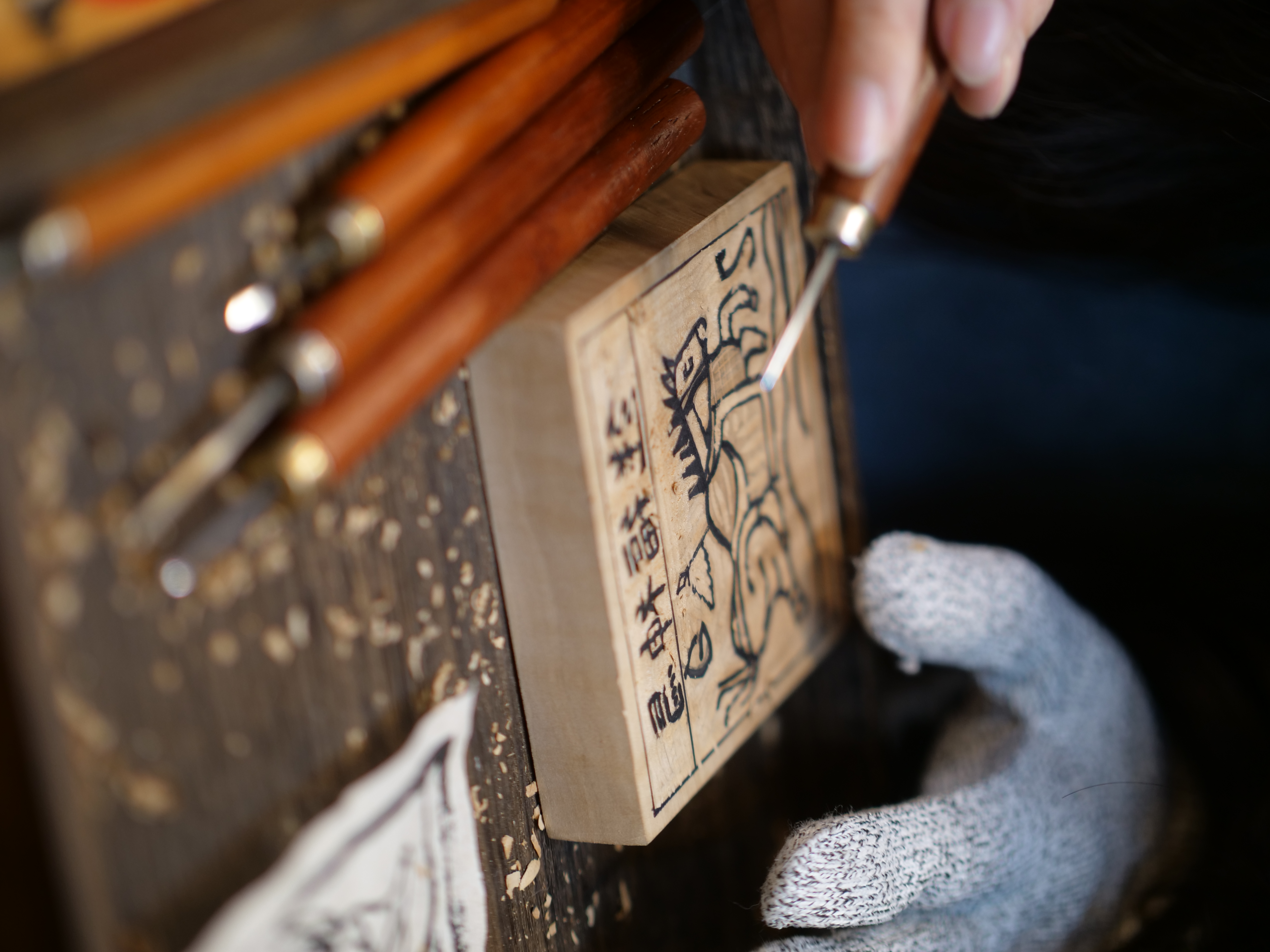 The second step is carving away the excess wood along the lines on the wooden block. /CGTN