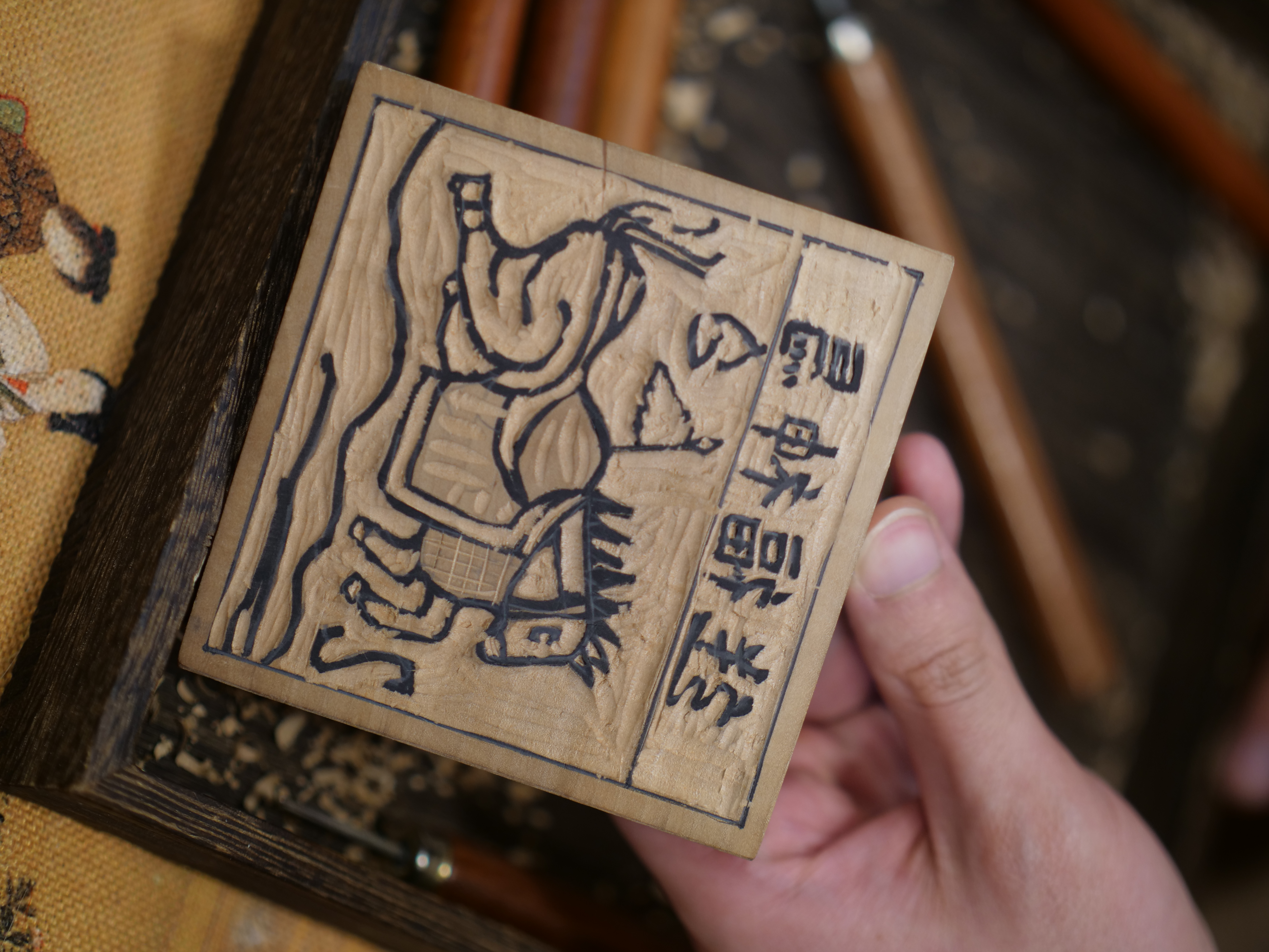 The second step is carving away the excess wood along the lines on the wooden block. /CGTN