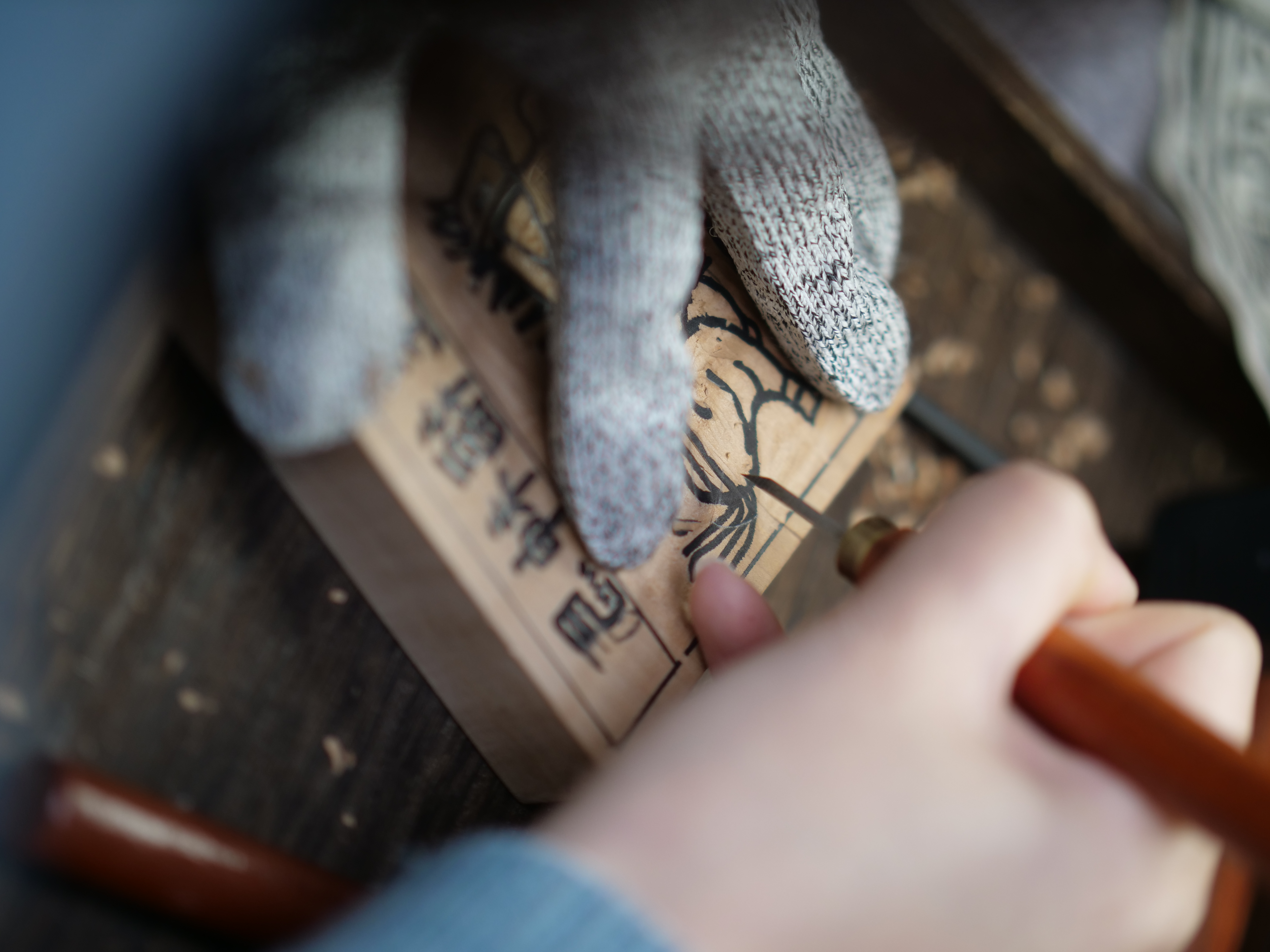 The second step is carving away the excess wood along the lines on the wooden block. /CGTN