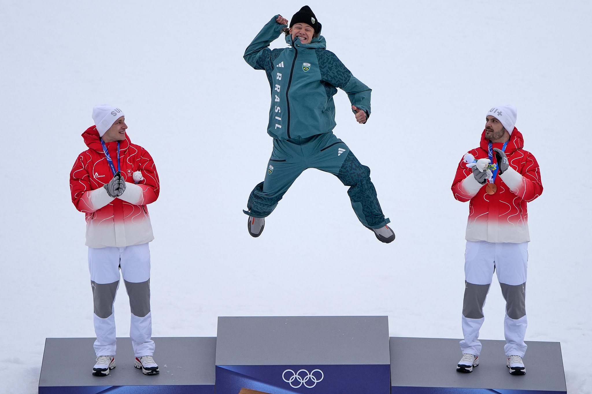 L-R: Silver medalist Marco Odermatt of Switzerland, gold medalist Lucas Pinheiro Braathen of Brazil and bronze medalist Loic Meillard of Switzerland celebrate the podium after the men's giant slalom Alpine skiing final at the 2026 Milano Cortina Winter Olympics in Bormio, Italy, February 14, 2026. /VCG