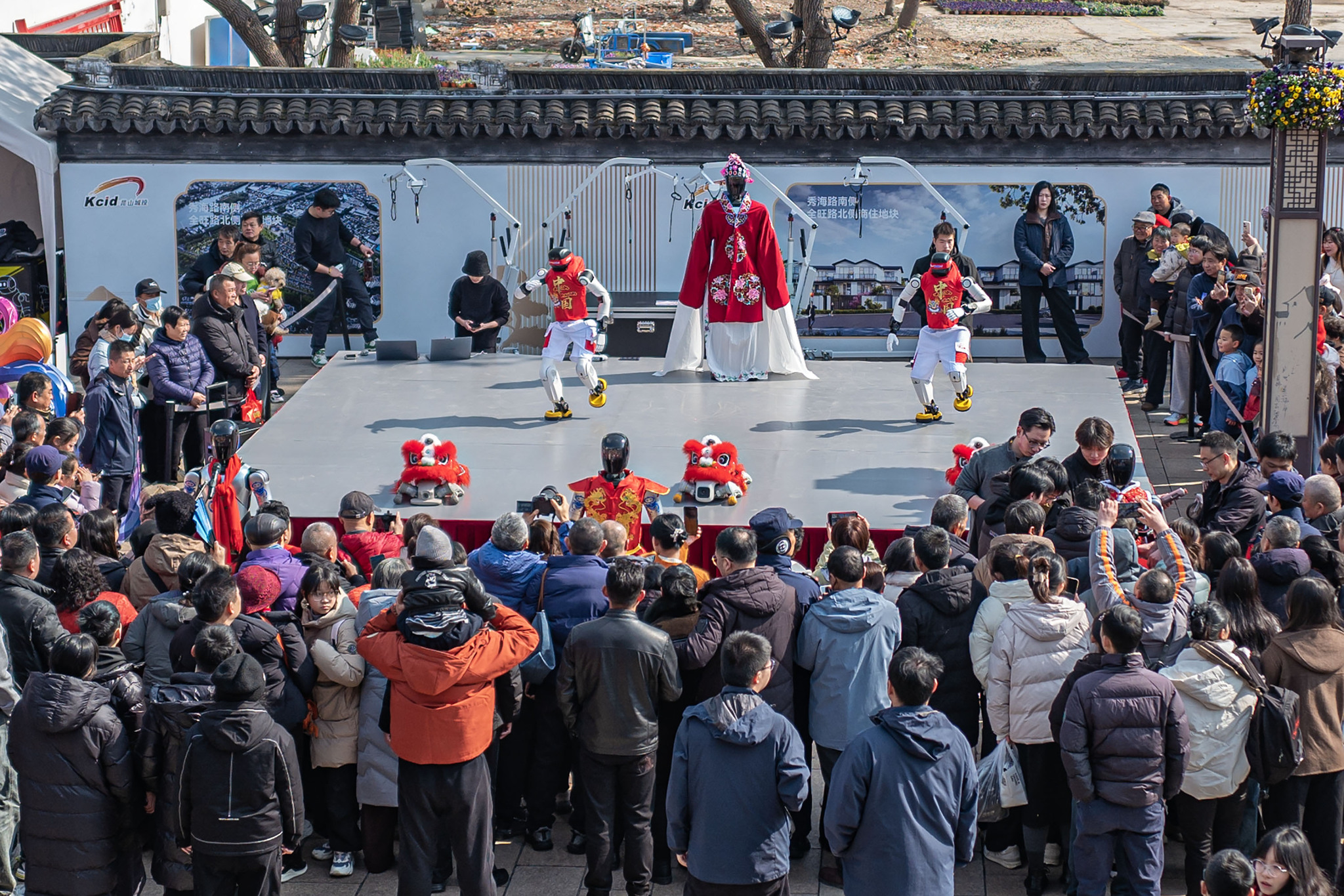 Humanoid robots, along with their dog companions, perform at the ancient town of Zhouzhuang in Kunshan, east China's Jiangsu Province, on February 17, 2026. /VCG