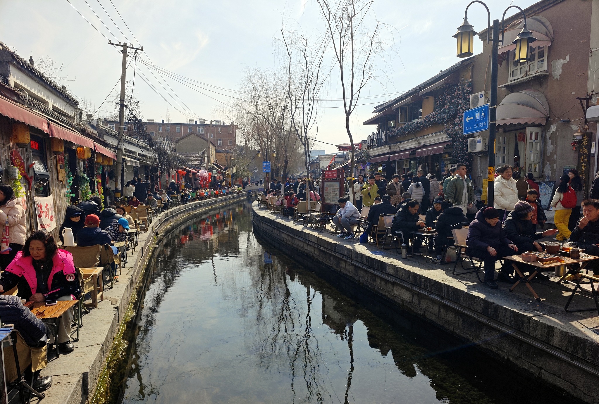 People sit by the river, brewing tea in Jinan, east China's Shandong Province, February 17, 2026. /VCG