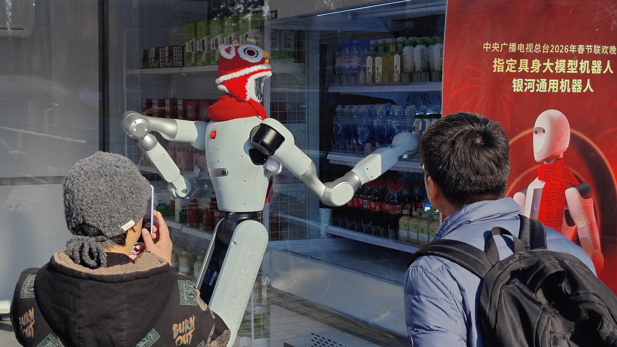 Tourists stop and watch how a humanoid robot independently handles the entire service process, from reception and order-taking to payment, pickup and delivery, Beijing, capital city of China, February 17, 2026. /CFP