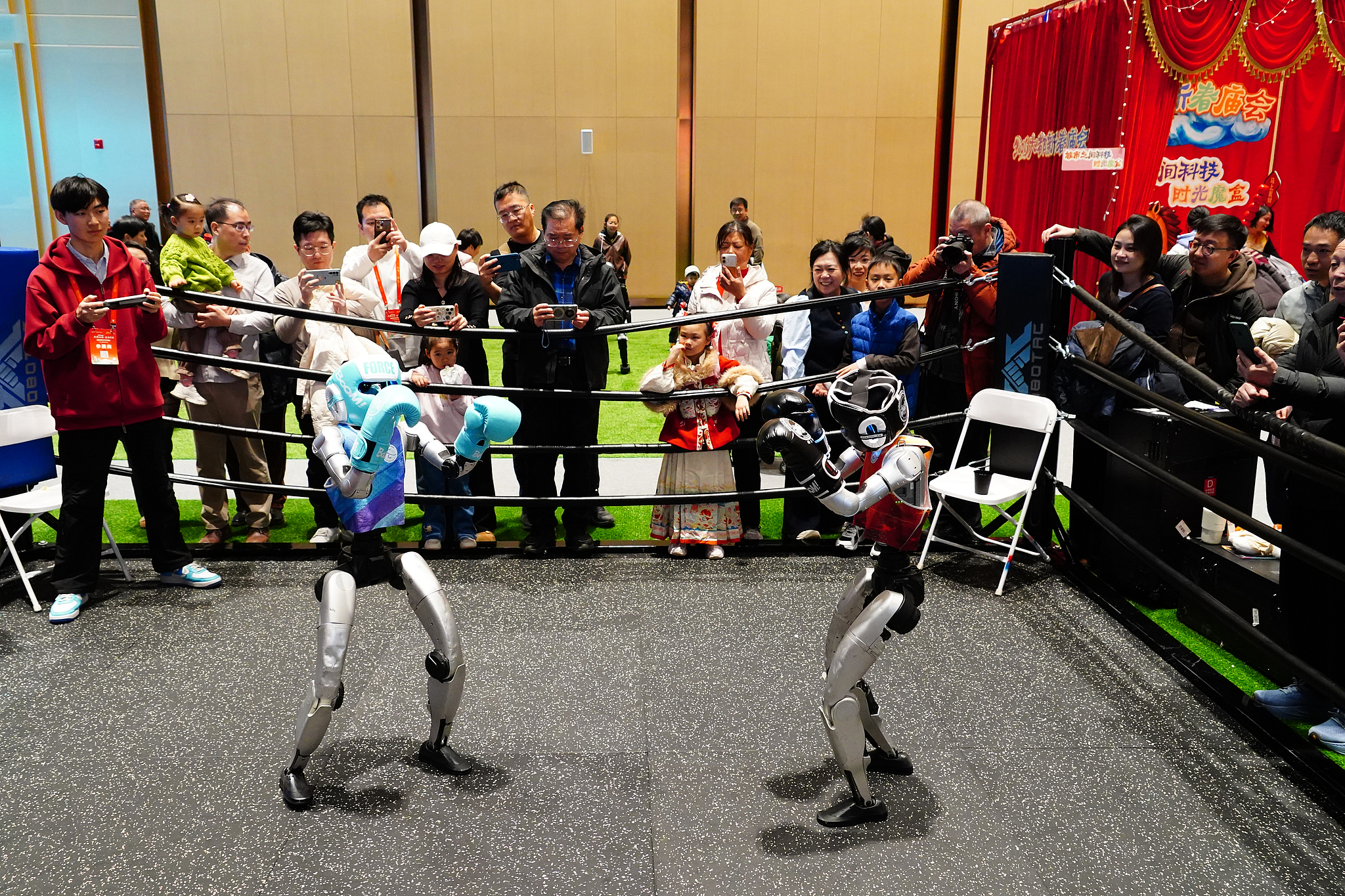 Robots appear on the boxing competition stage in a temple fair in Beijing, February 18, 2026. /VCG