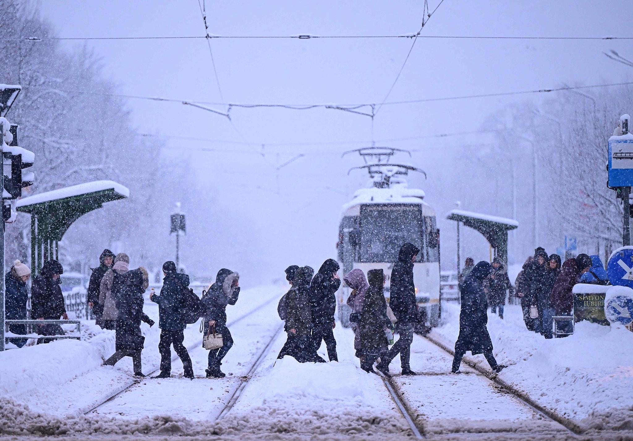 People cross a street under heavy snowfall in Bucharest, Romania, February 18, 2026. /VCG