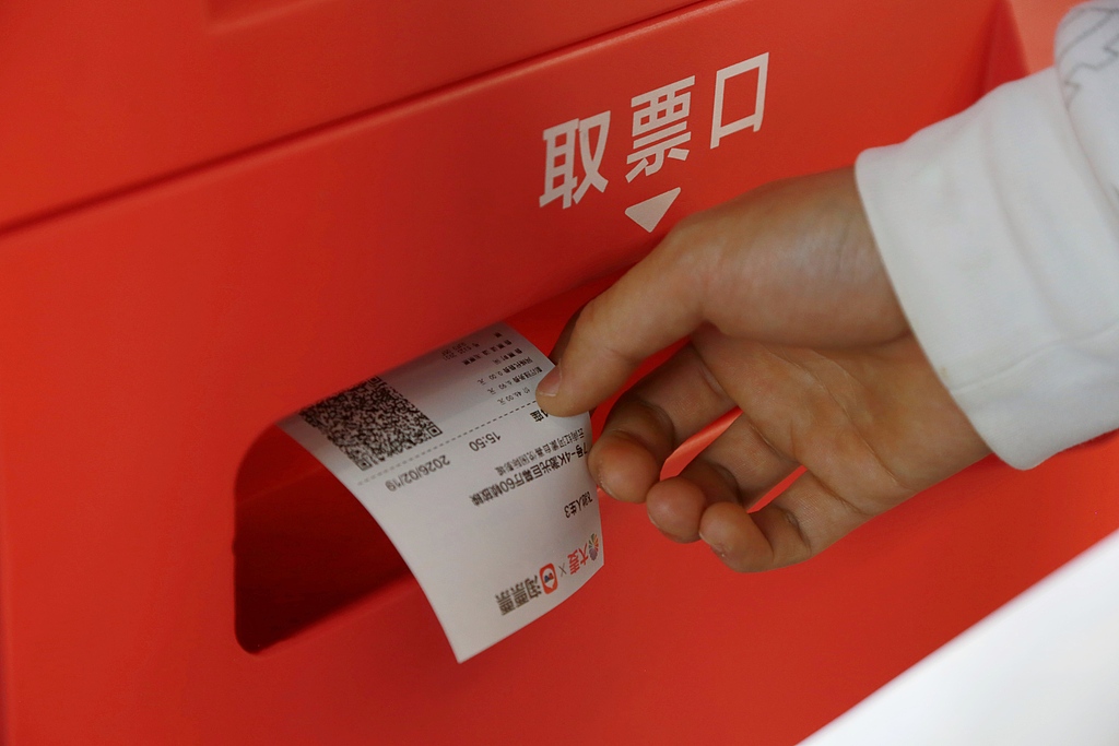 A moviegoer collects a ticket from a self-service ticket machine at a cinema in Mengzi, in Yunnan Province on February 19, 2026. /VCG