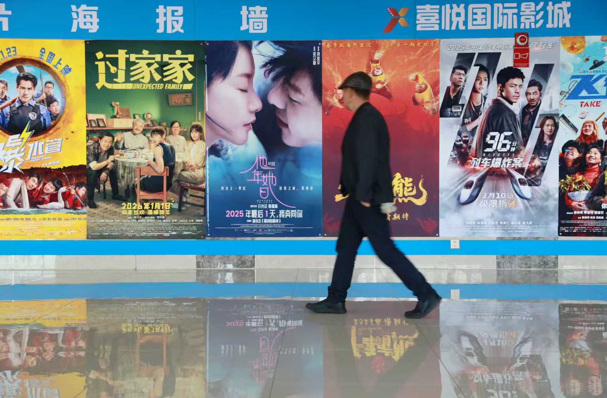 Moviegoers walk past a wall of film posters. As multiple releases hit the big screen during the Spring Festival holiday, audiences not only flock to cinemas to celebrate the season but also go to the scenic spots featured in the movies. /CFP