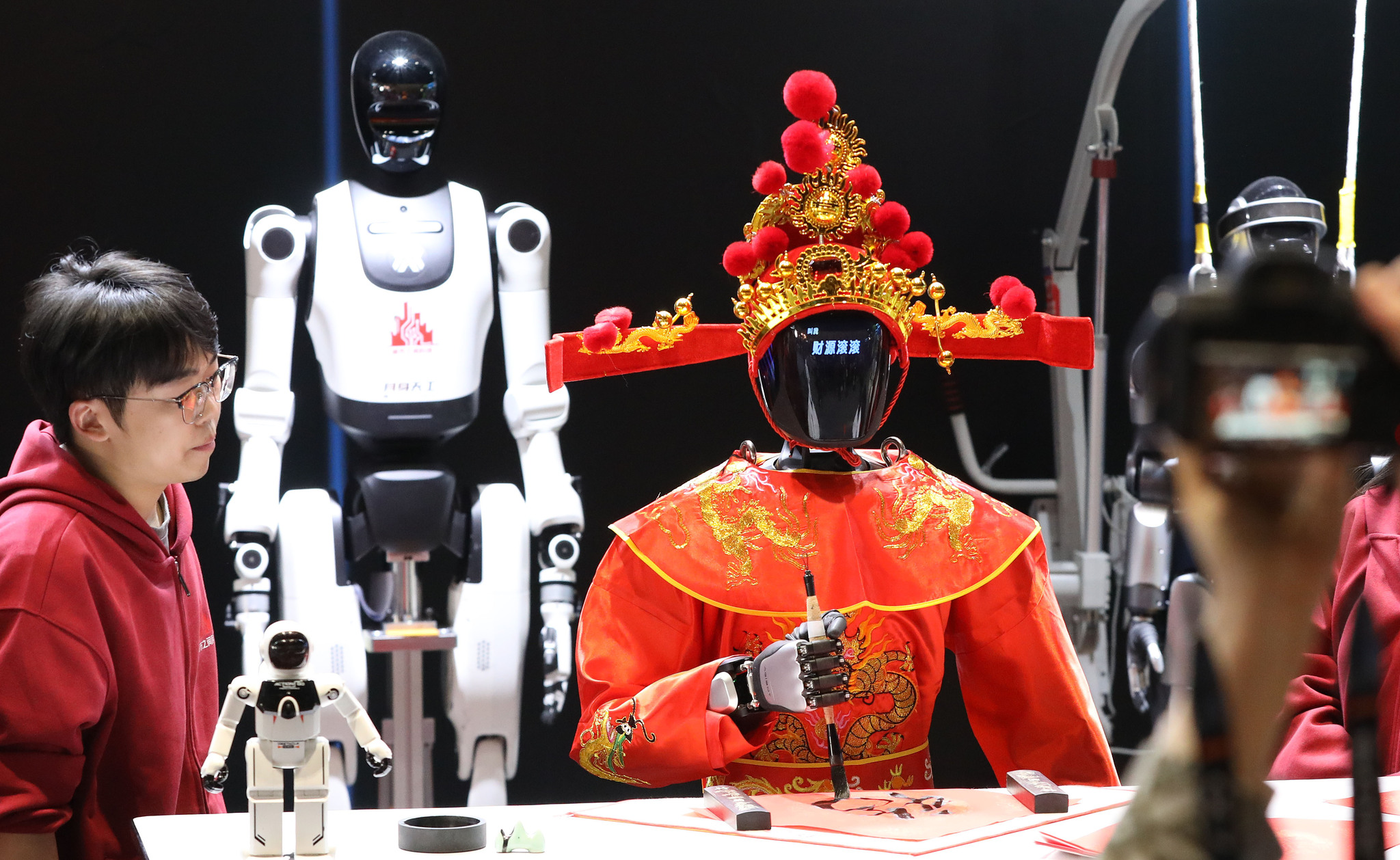 A robot Chinese God of Wealth is pictured writing blessing characters at the 2026 Dadu Spring Festival Temple Fair in Beijing on February 20, 2026. /VCG
