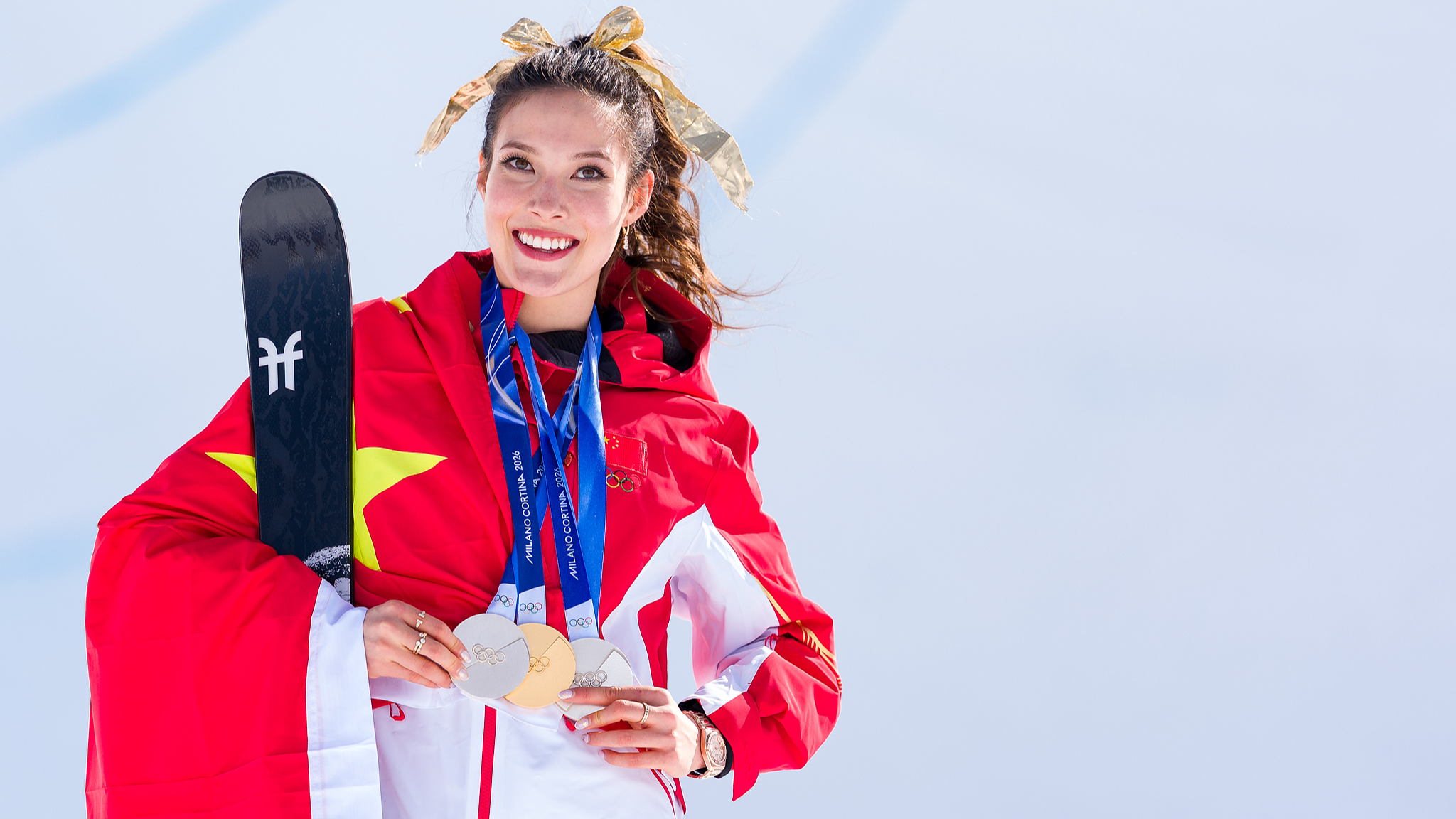 China's Gu Ailing celebrates holding her three medals won in Slopestyle, Big Air and Halfpipe competitions during the medal ceremony for the Women's Freeski Halfpipe Final at the Milano Cortina Games in Livigno, Italy, February 22, 2026. /VCG