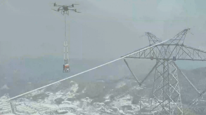 A drone places a de-icing robot on a cable, east China's Anhui Province. /CMG