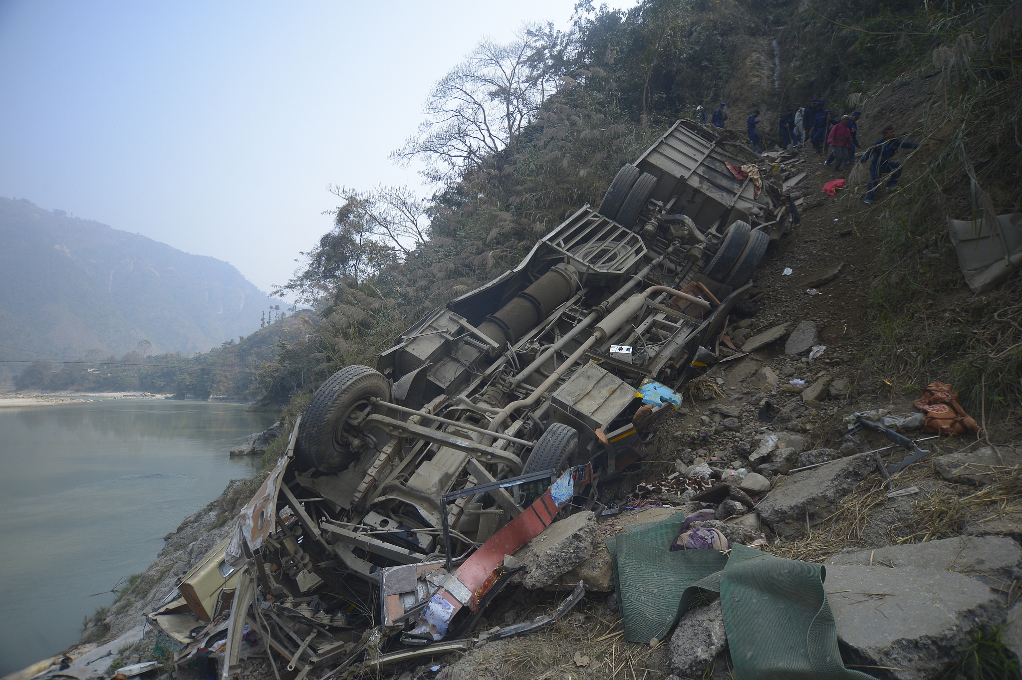 The wreckage of a bus is seen on the bank of the Trishuli River after it drove off a mountain highway near Benighat, west of the capital, Kathmandu, Nepal, February 23, 2026. /VCG
