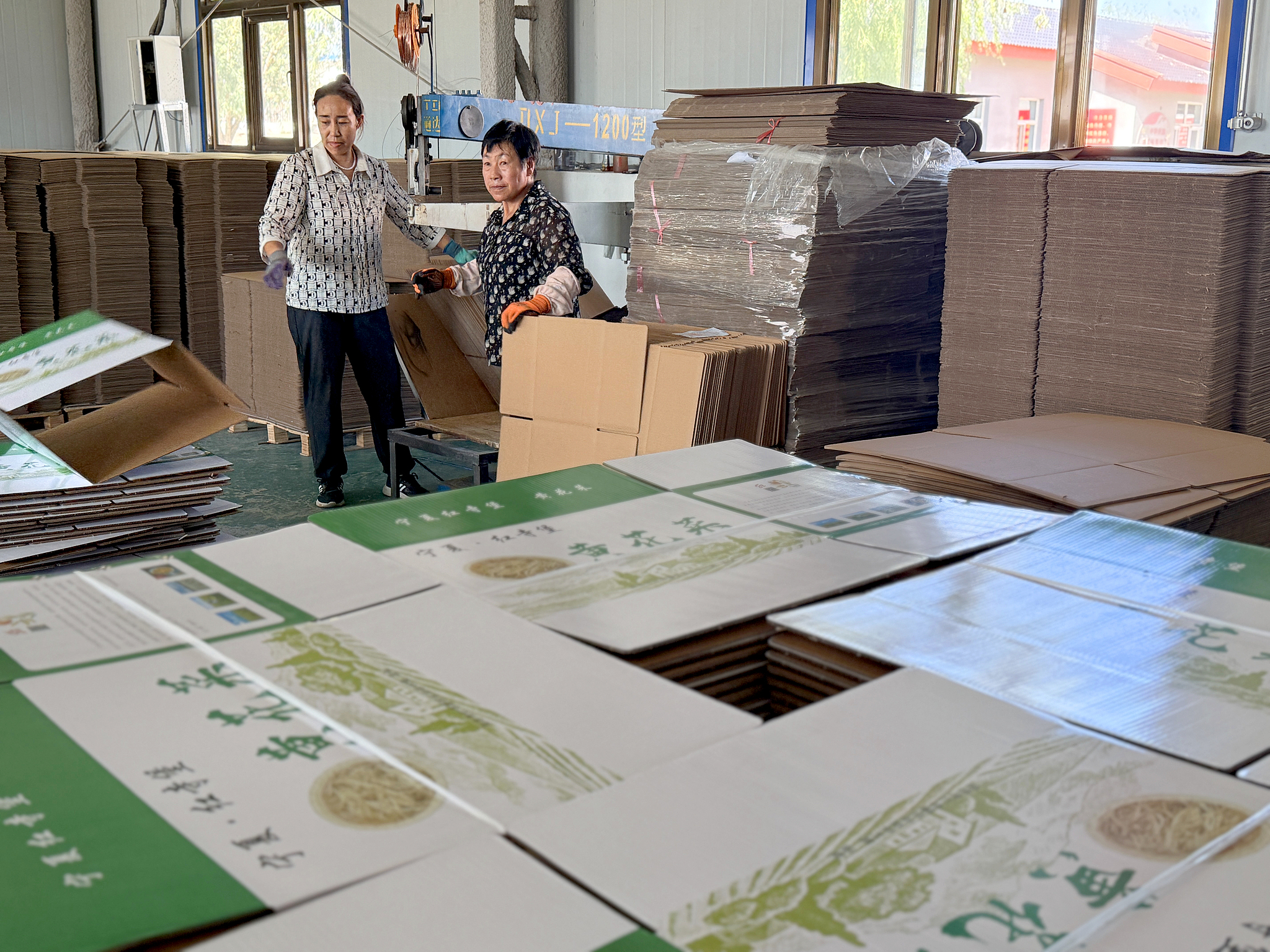 Villagers processing and making cardboard boxes at a poverty alleviation workshop in Hongde village, Wuzhong city, in Ningxia Hui Autonomous Region. July 29, 2025. /VCG