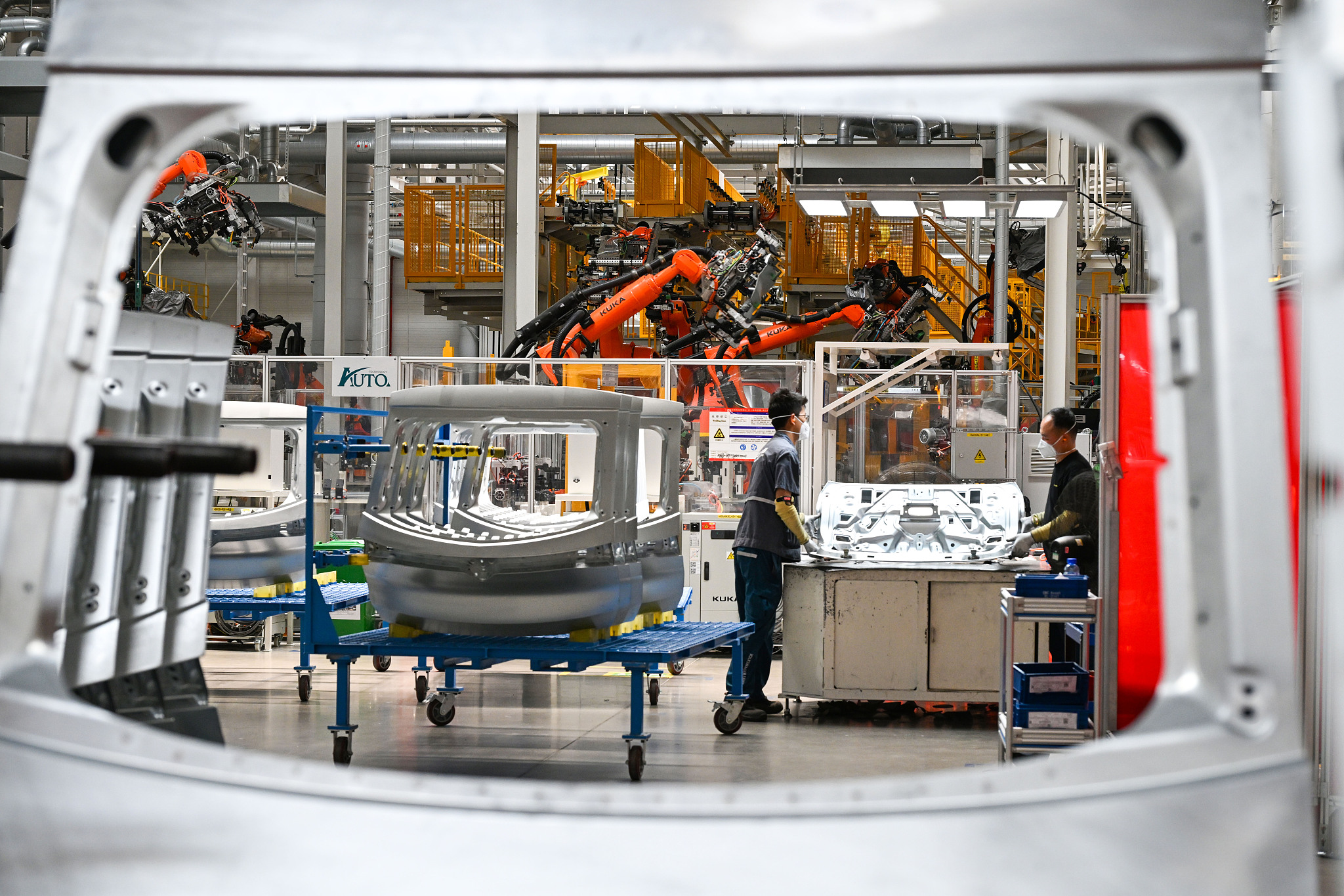Industrial workers and robotic arms were operating on the production line at Volkswagen (Anhui) Automotive Company in Hefei, Anhui Province, May 21, 2025. /VCG