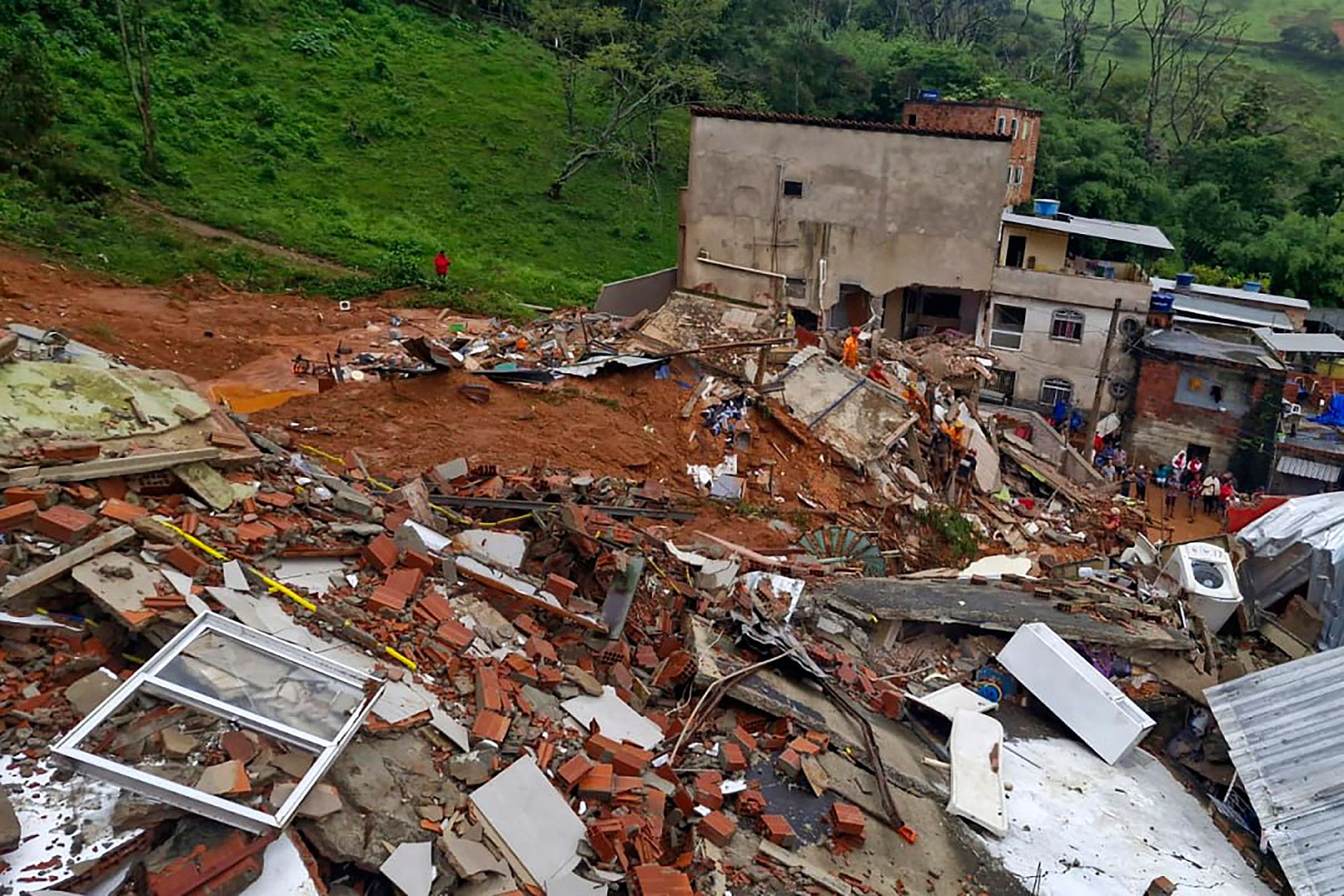 Firemen work at a building destroyed by heavy rains in Juiz de Fora, Minas Gerais, Brazil, February 24, 2026. /VCG