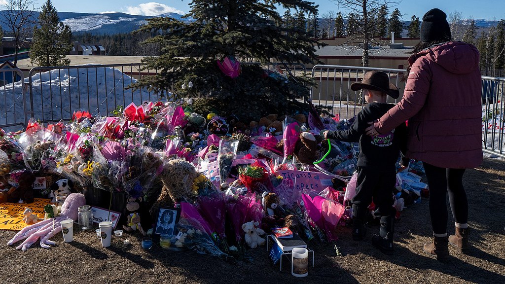 A mother and son pay their respect at a memorial for the victims of a mass shooting in Tumbler Ridge, British Columbia, February 14, 2026. /VCG