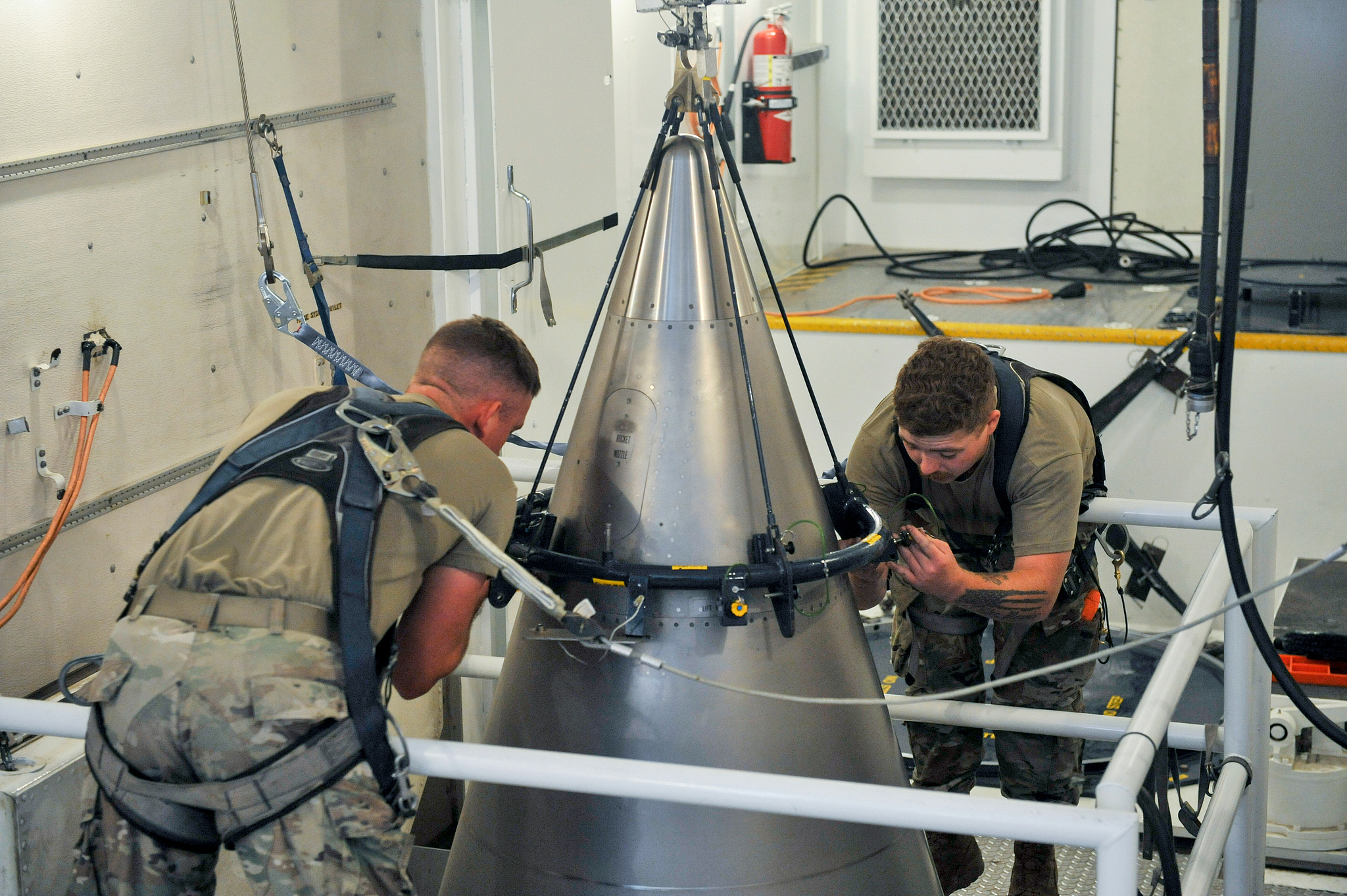 U.S. Air Force airmen securing a titanium shroud over a nuclear warhead at the top of a Minuteman III intercontinental ballistic missile, Aug. 24, 2023. /VCG