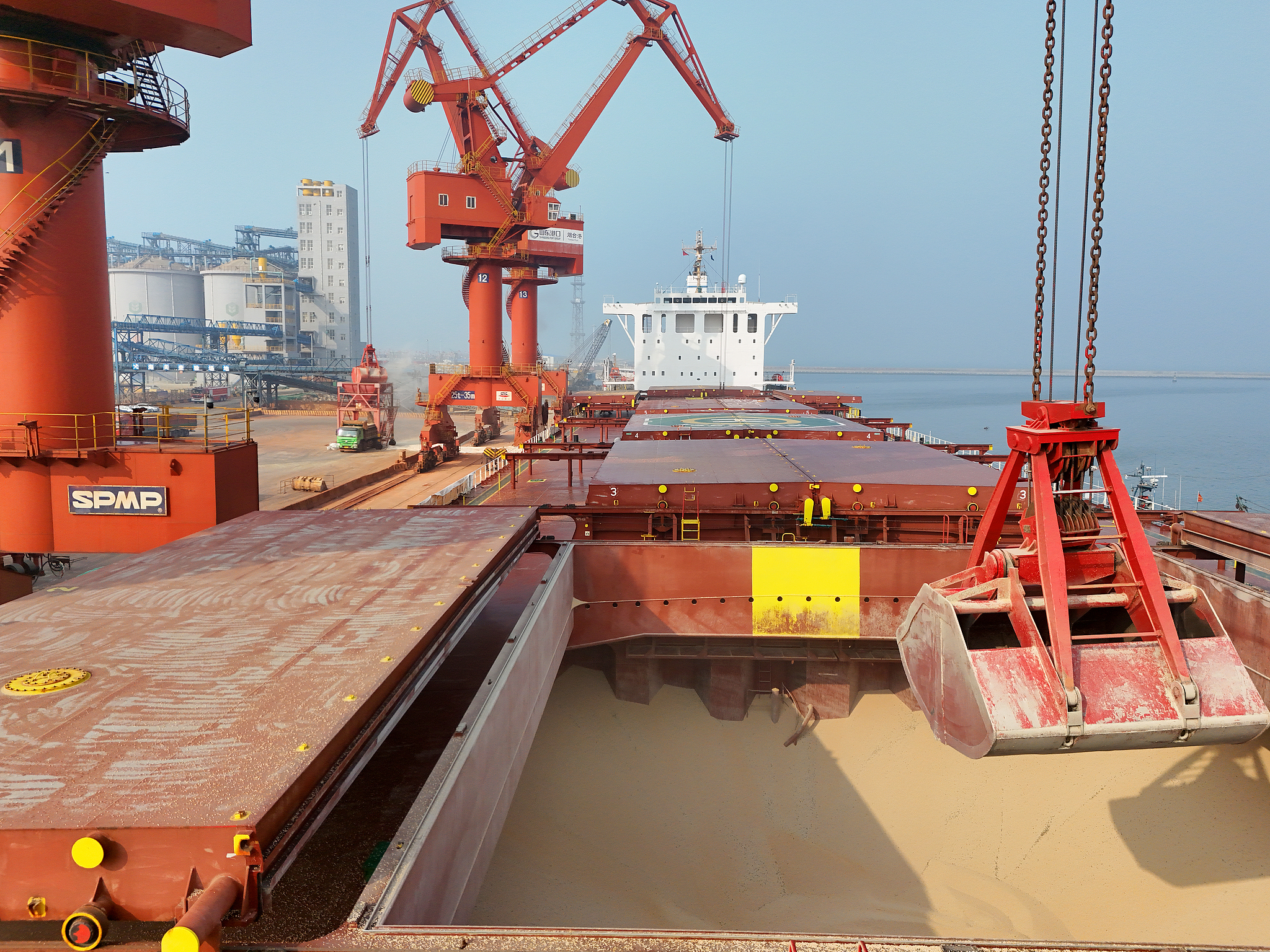 A crane unloading peas imported from Canada at Laizhou Port Area of ​​Yantai, in Shandong Province. February 28, 2025. /VCG